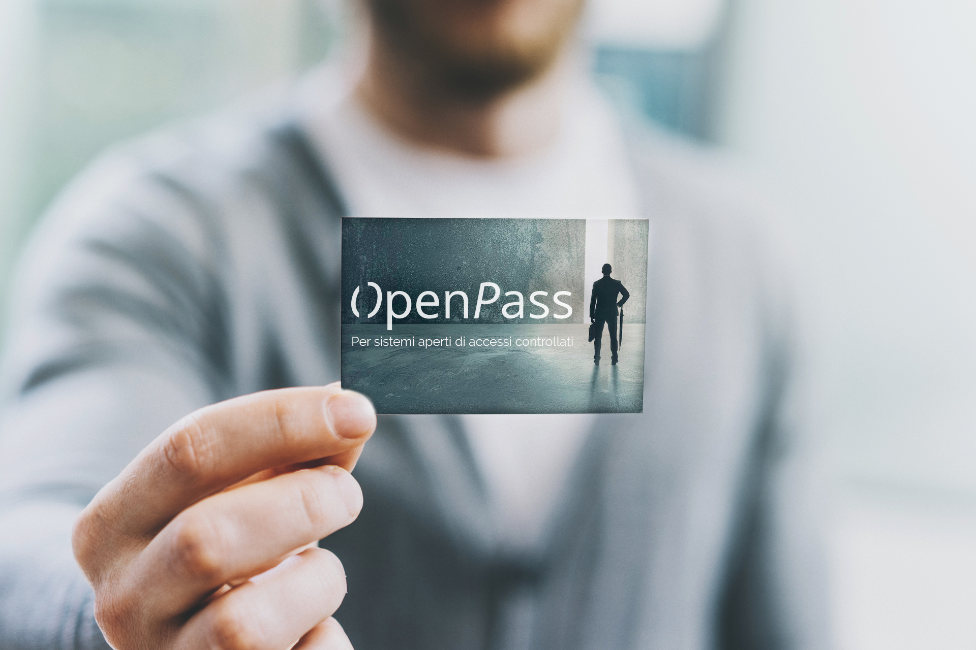Closeup photo man wearing casual shirt and showing blank white business card. Blurred background. Ready for private information. Horizontal mockup