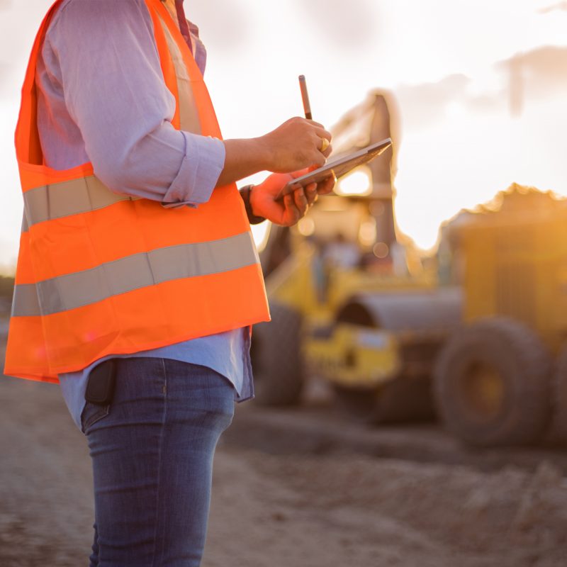 Asian engineer with hardhat using tablet pc computer inspecting